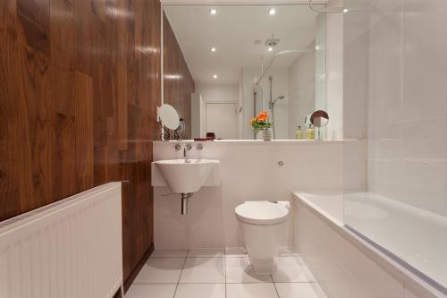 a white bathroom with a toilet and a sink at 118 Brondesbury Road Apartments in London