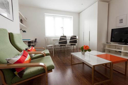 a living room with a couch and a table at 118 Brondesbury Road Apartments in London