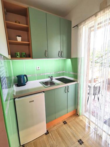 a kitchen with green cabinets and a sink at Durakovic Apartments in Herceg-Novi