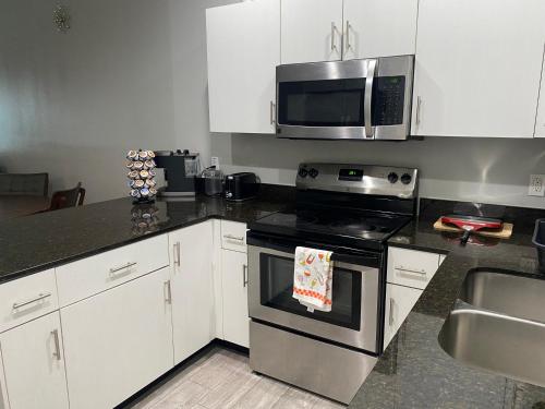 a kitchen with a stove and a microwave at Cozy Getaway with King Bed near UTRGV in Edinburg