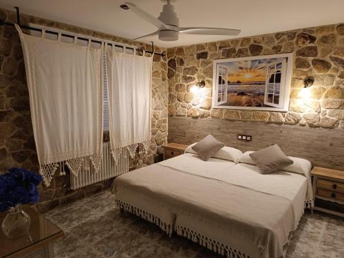 sypialnia z łóżkiem i wentylatorem sufitowym w obiekcie Casa Rural Outeiro w mieście Outeiro