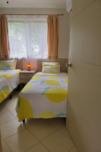 a bedroom with two beds and a window at Coco Dream Escapes Ground Unit in Coco