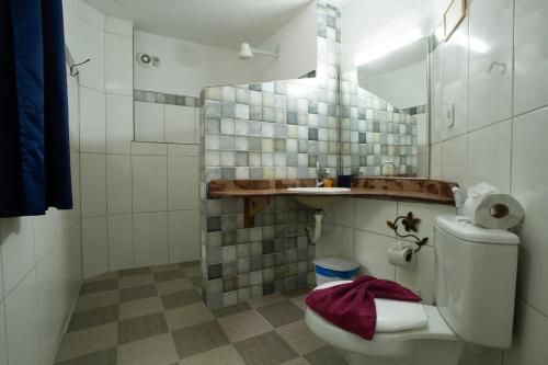 a white bathroom with a toilet and a sink at Pousada Canto No Bosque in Lençóis