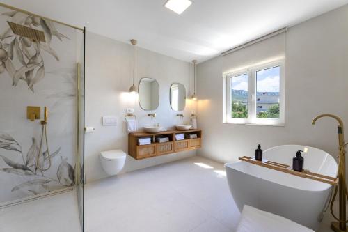een badkamer met een bad, een toilet en een wastafel bij Olive apartment in Kaštela