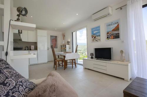 un salon avec une télévision et une table avec des chaises dans l'établissement Villa Campo di Pace, à Sisco