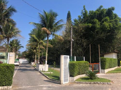 a street with palm trees and a fence at Casa Condomínio Juquehy 100 M do Centrinho in Juquei