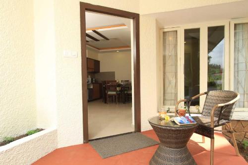 a door to a patio with a table and chairs at Sterling Ooty Fern Hill in Ooty