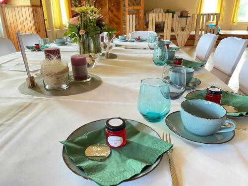 a long table with a white table cloth with plates on it at Gasthaus Neue Mühle in Westhausen