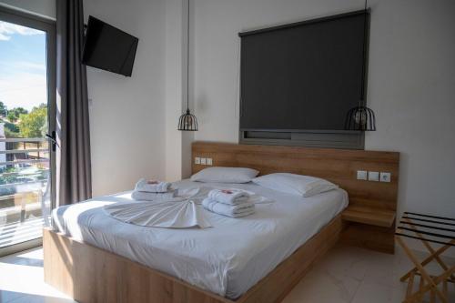 a bedroom with a bed with towels on it at Finikas Suites & Apartments Airport By Airstay in Artemida