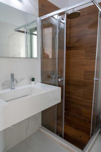 a bathroom with a sink and a shower at Finikas Suites & Apartments Airport By Airstay in Artemida