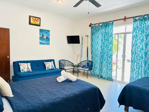 a bedroom with a blue bed with a stuffed animal on it at Departamentos Blue Bacalar in Bacalar