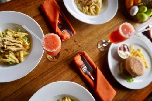 a table with plates of food and a drink at Houttuyn Wellness River Resort in Paramaribo