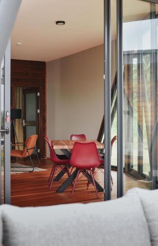 a living room with red chairs and a table at Houttuyn Wellness River Resort in Paramaribo