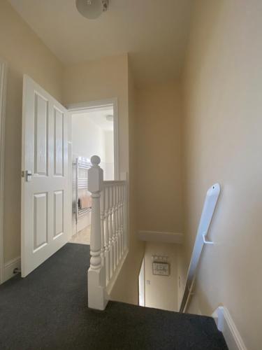 a stairway with a white door and a stair railing at BeRo Terrace, only a minutes walk to the beach! in Withernsea