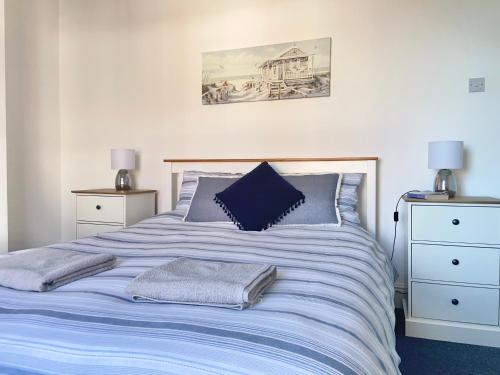 a bed with blue sheets and pillows in a bedroom at BeRo Terrace, only a minutes walk to the beach! in Withernsea