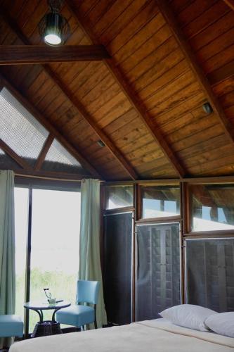 a bedroom with a bed and a table and chairs at Houttuyn Wellness River Resort in Paramaribo