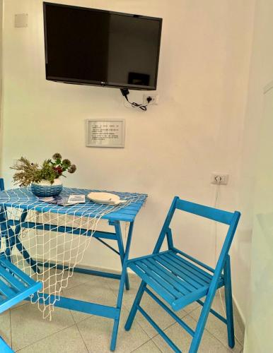a table with two chairs and a television on a wall at PonzaSmeralda Le Forna in Ponza