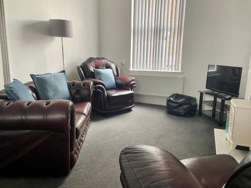 a living room with two leather chairs and a television at BeRo Terrace, only a minutes walk to the beach! in Withernsea