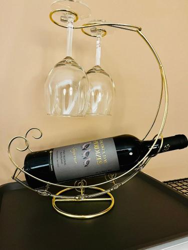 a wine bottle in a wine rack with two glasses at Refugio do Gato in Palmela