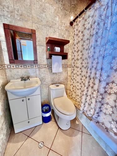a bathroom with a toilet and a sink at Hotel Sierra Negra in Puerto Villamil