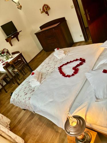 a bed with a white blanket with a red heart on it at Penzion Pohádka in Třeboň