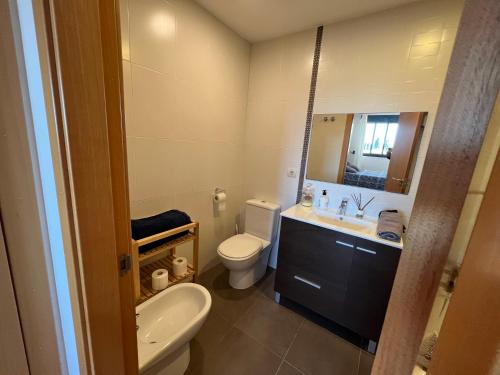a bathroom with a toilet and a sink and a mirror at WONDERFUL APARTMENT IN CANET DE BERENGUER. VALENCIA in Valencia