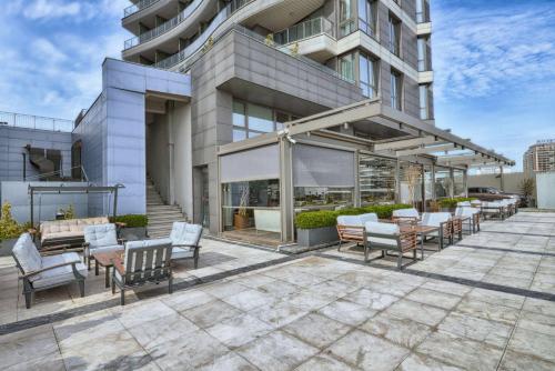 un patio con sillas y mesas frente a un edificio en Best Western Premier Ottoperla Hotel, en Estambul