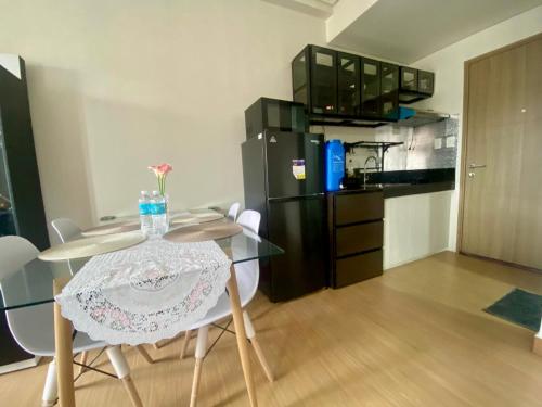a kitchen with a glass table and a black refrigerator at J & F Homestay - Cavite, Philippines in Trece Martires