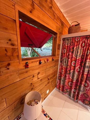 a window in a wooden room with a curtain at Rêve de Cabane in Capesterre-de-Marie-Galante