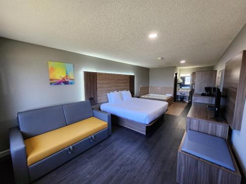 a hotel room with a bed and a couch at Super 8 by Wyndham Hayward WI in Hayward
