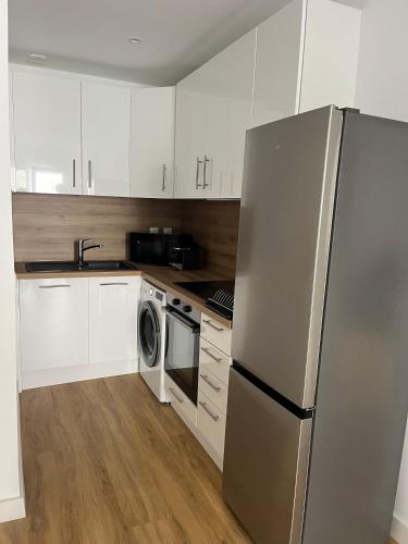  La cuisine est équipée de placards blancs et d'un réfrigérateur. dans l'établissement Bandol T3 à deux pas du port et des plages, à Bandol