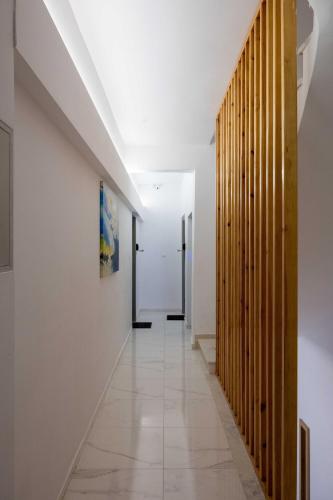 a hallway with white walls and a wooden partition at Finikas Suites & Apartments Airport By Airstay in Artemida