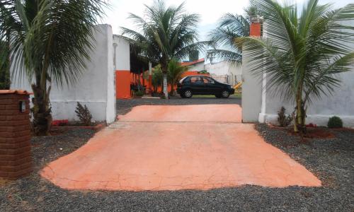 a driveway with a car parked next to a house at Pousada Sol Nascente in Olímpia