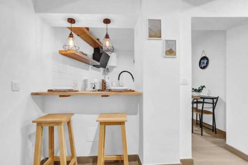 cocina con taburetes de madera y encimera con fregadero en Casa Los Holandeses, en Buenavista del Norte
