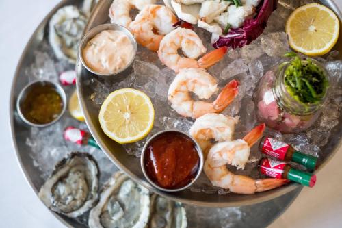 a platter of shrimp and other foods on a plate at Reikart House Buffalo, a Tribute Portfolio Hotel in Amherst
