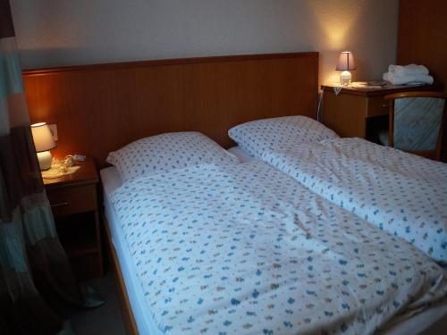 a large bed in a bedroom with two night stands at Landhotel Wilhelm Busch in Lüthorst