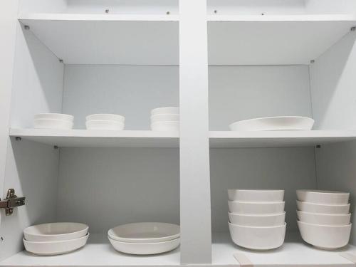 a white shelf with white bowls and plates on it at Seoul House in Seoul