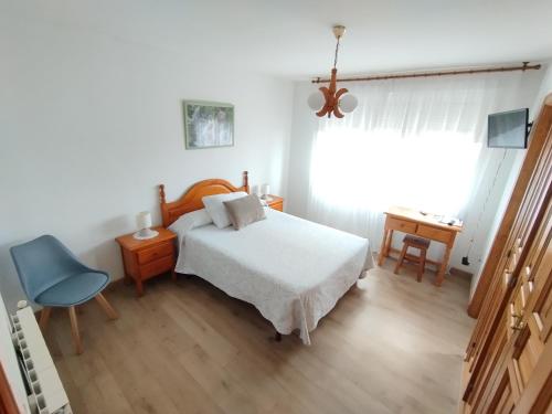 サン・ビセンテ・デ・ラ・バルケラにあるAlto Santiagoのベッドルーム1室(ベッド1台、青い椅子付)