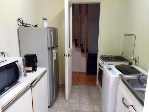 a small kitchen with a refrigerator and a stove at Casa Valle Volcanes 3 Dormitorios in Puerto Montt