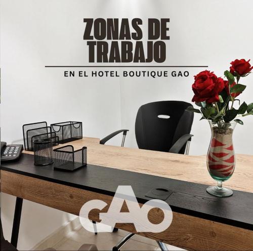 a table with a vase with roses in it at Hotel Boutique Gao in Cúcuta