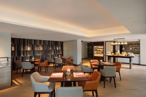 a restaurant with tables and chairs in a room at Marriott Executive Apartments Bangkok, Sukhumvit 50 in Bangkok