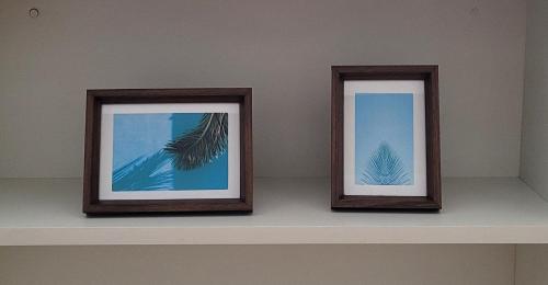 two picture frames sitting on a shelf at Blend Coliving One - 2a in Ribeirão Preto