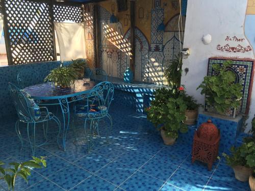 eine Terrasse mit einem Tisch, Stühlen und Topfpflanzen in der Unterkunft HATHOR ,Casa marroquí con dos terrazas en la Medina antigua , ideal parejas!! WIFI!! in Asilah