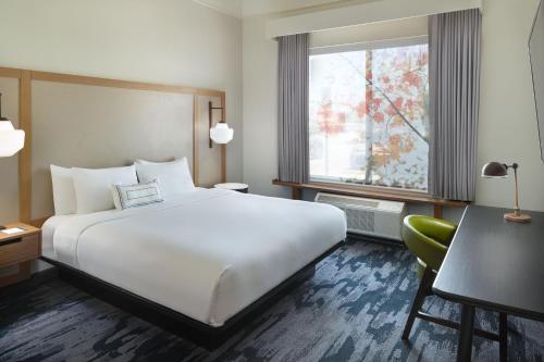 a hotel room with a bed and a desk and a window at Fairfield Inn & Suites Locust Grove I-75 South in Locust Grove