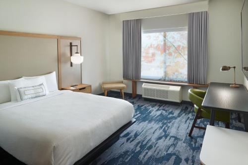 a hotel room with a bed and a desk at Fairfield Inn & Suites Locust Grove I-75 South in Locust Grove