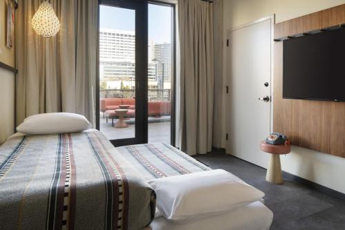 a hotel room with a bed and a flat screen tv at Moxy Oakland Downtown in Oakland