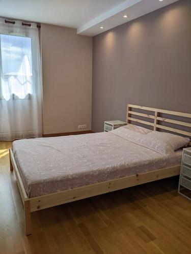 une chambre avec un lit dans une pièce avec une fenêtre dans l'établissement L'appartement du Parc, à Cachan