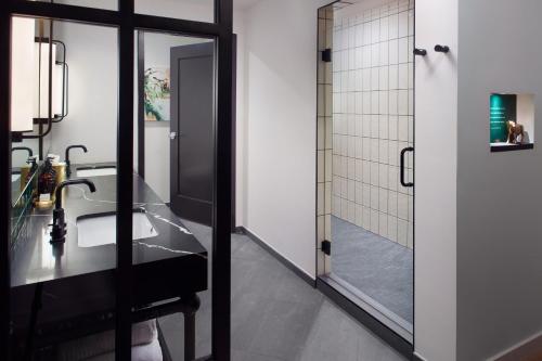 a bathroom with a sink and a mirror at Bellyard, West Midtown Atlanta, a Tribute Portfolio Hotel in Atlanta