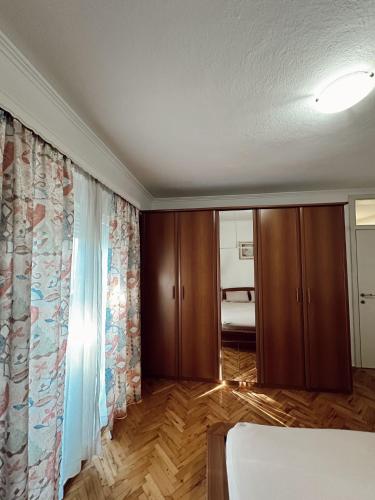 a bedroom with a bed and a room with a bed and curtains at Apartman Rose in Čitluk
