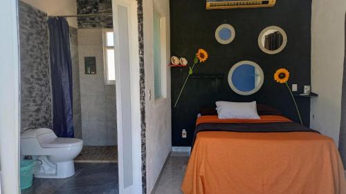 a bedroom with a bed and a toilet and mirrors at Casa brisas del mar in Ipala